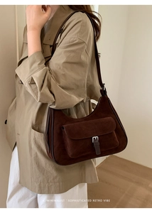 Detailed view of dark brown retro suede underarm bag on model with silver buckle detail