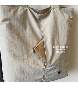 Détail d'un sac cabas en nylon imperméable avec poche avant pour un portefeuille