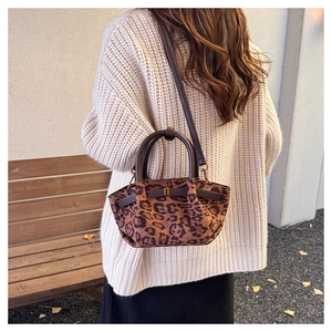 Detail of leopard print handbag with leather ring handle and crossbody strap