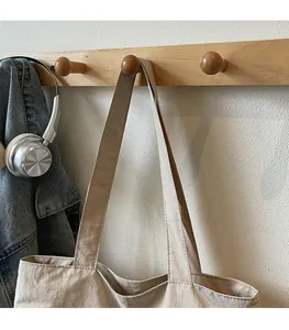Détail de la large bandoulière confortable et coutures fines du sac fourre-tout beige