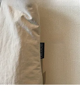 Gros plan sur l'étiquette de marque noire cousue sur le côté d'un sac cabas en toile beige