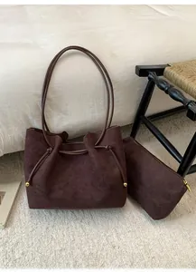 Close-up of brown suede tote bag with drawstring detail and matching inner pouch