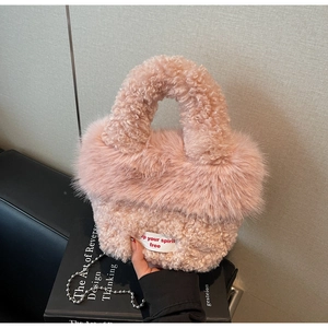 Détail du sac à main rose en peluche avec poignée en laine d'agneau et chaîne en métal