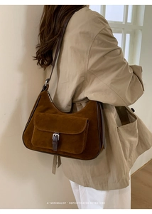 Brown faux suede hobo bag shown in a 3/4 back view on a model with minimalist retro vibes