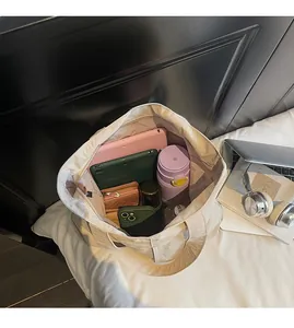 Intérieur spacieux du sac cabas beige montrant des compartiments pour tablettes et objets