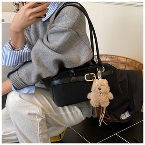 Detailansicht schwarze Vintage Umhängetasche mit goldener Schnalle und braunem Teddybär-Anhänger