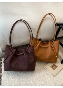 Detail of vintage suede tote bags in coffee and camel with slim leather shoulder straps