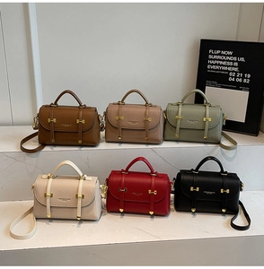 Detail shot of vintage leather satchel bags in six colors on marble stairs