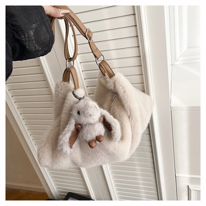 Dettaglio della borsa a tracolla in peluche con cinturino marrone e ciondolo a coniglietto