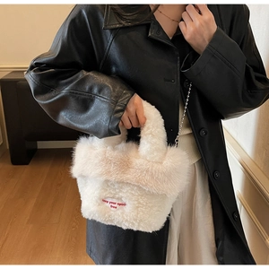 Détail d'un sac à main blanc en fausse fourrure avec peluche douce et chaîne à billes