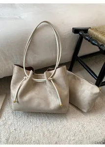 Detail of apricot tote bag with drawstring closure and golden sphere accents