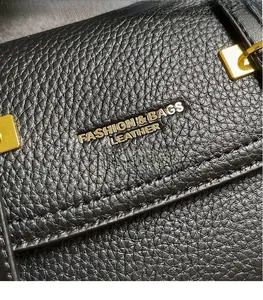 Detail of black lychee grain leather texture with gold buckle and fashion engraving