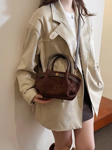 Frosted dark coffee hobo bag with top handle and shoulder strap worn with an ivory blazer