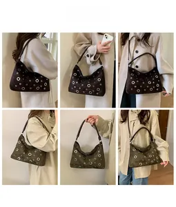 Retro hollowed-out suede shoulder bag with eyelet details worn by an Asian model