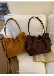 Detailed macro view of camel and brown suede tote bags with metallic bead drawstrings