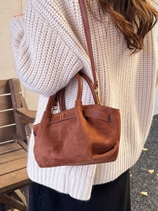 Vintage brown matte suede handbag with crossbody strap shown in a cozy street style setting