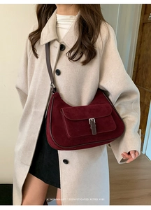 Close-up of matte wine red shoulder bag with buckle and retro minimalist aesthetic