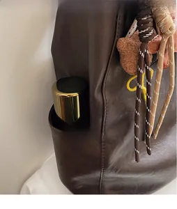Détail du grand sac seau rétro marron foncé avec poche latérale et breloque peluche