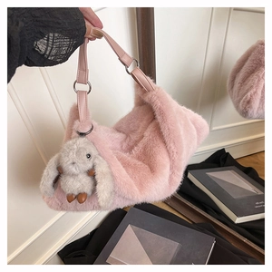 Dettaglio della borsa a tracolla rosa in peluche con texture soffice e ciondolo a coniglio