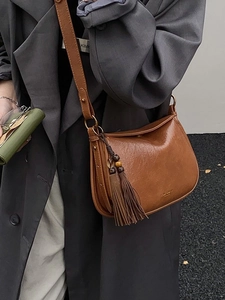 Retro brown leather saddle bag with tassel detail and adjustable shoulder strap