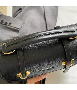 Close-up of black lychee grain leather handbag with gold metal hardware and smooth handle
