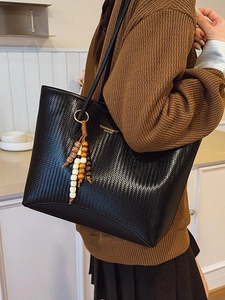 Retro black woven leather tote bag for women with decorative beaded tassel and gold lettering