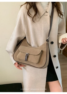 Detail of minimalist khaki suede shoulder bag with retro brown strap and metal buckle