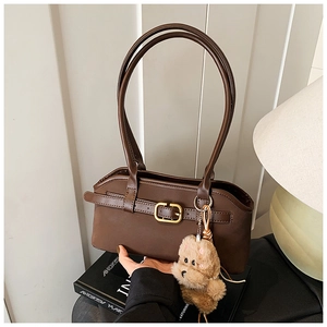 Detailansicht der dunkelbraunen Kunstleder-Handtasche mit einem niedlichen Bärenanhänger