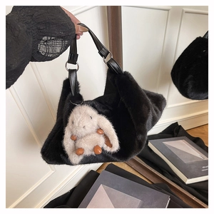 Dettaglio della borsa a tracolla in ecopelliccia nera con un dolce coniglio di peluche beige