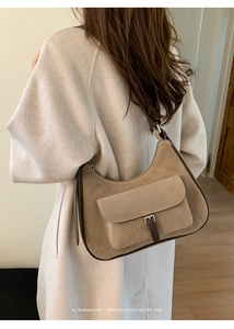 Detailed view of khaki suede underarm bag on model showing retro design and texture