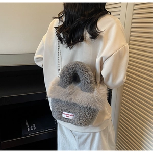Détail du sac seau en fausse fourrure grise avec bordure pelucheuse et bandoulière