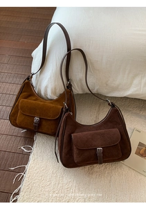 Retro suede hobo bags in ginger and coffee brown shown on a soft white plush rug