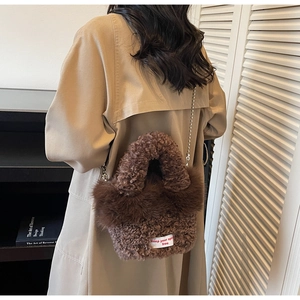 Détail du sac seau en laine d'agneau marron foncé avec bandoulière en chaîne argentée