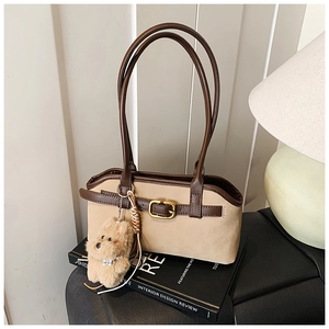 Detail einer Vintage-Schultertasche aus beigem Wildleder mit braunem Lederbesatz