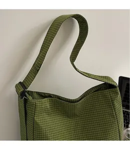 Detail view of the green checkered tote bag showing smooth adjustable wide shoulder strap