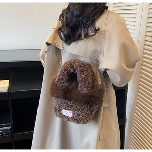 Détail du sac peluche marron avec texture duveteuse, chaîne et label spirit free