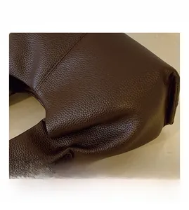 Close-up of brown litchi pattern leather with stitching and silver metal hook buckle