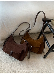 Detail of retro suede shoulder bags showing fine texture and sleek leather strap