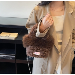 Vue détaillée du sac seau marron en peluche avec texture laine d'agneau et bandoulière