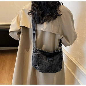 Detailed back view of a retro washed black denim crossbody bag with metal plaque decoration