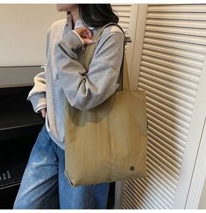 Détail du sac cabas en nylon kaki imperméable avec son logo métallique circulaire