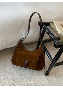 Macro shot of vintage brown suede underarm bag with silver hardware and leather strap