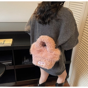 Détail du sac à main rose en peluche avec bandoulière chaîne et étiquette tissée