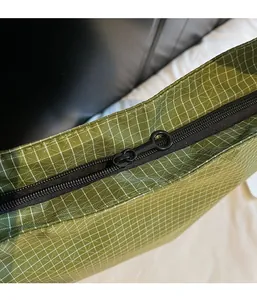 Detail of smooth double zipper and green mesh fabric texture on large tote bag