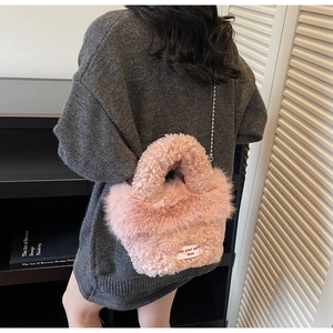 Détail d'un sac seau rose en fausse fourrure avec texture agneau et bandoulière chaîne