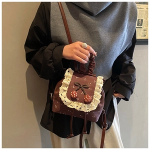 Détail du mini sac à dos vintage marron foncé avec cerises et bordures en dentelle