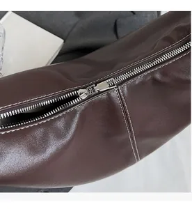Gros plan sur la fermeture éclair et les surpiqûres blanches du sac cabas marron foncé
