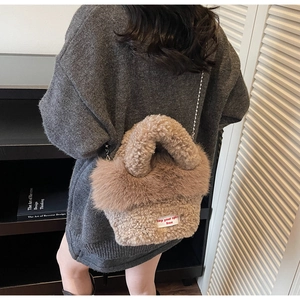Détail d'un sac à main en fausse fourrure kaki doux avec texture peluche et chaîne en argent