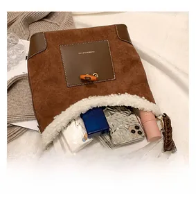 Interior view of brown suede bucket bag showing storage for phone and lipstick