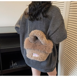 Détail du sac seau en laine d'agneau pelucheuse avec chaîne et étiquette blanche